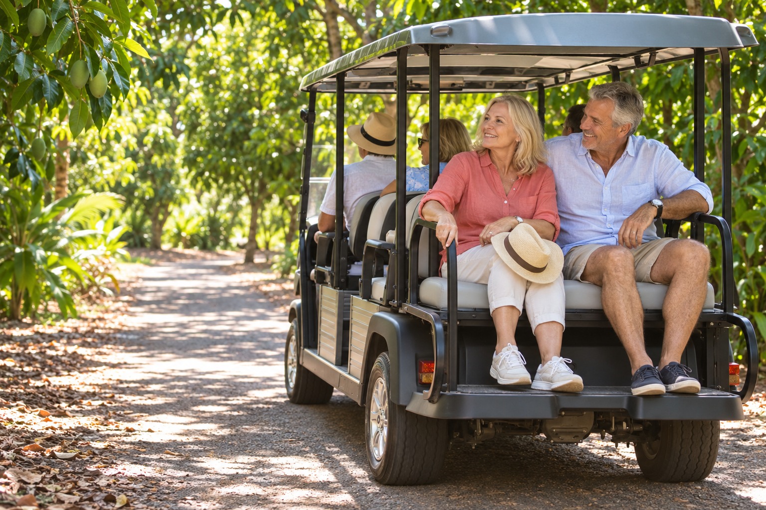 Mature travellers enjoying a buggy tour through a sunlit tropical orchard